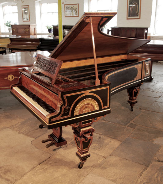 An 1861, Erard  grand piano with an ornate burr walnut, black and gilt cabinet by cabinet maker William Lomax. Piano casework features Egyptian Revival and Neoclassical elements