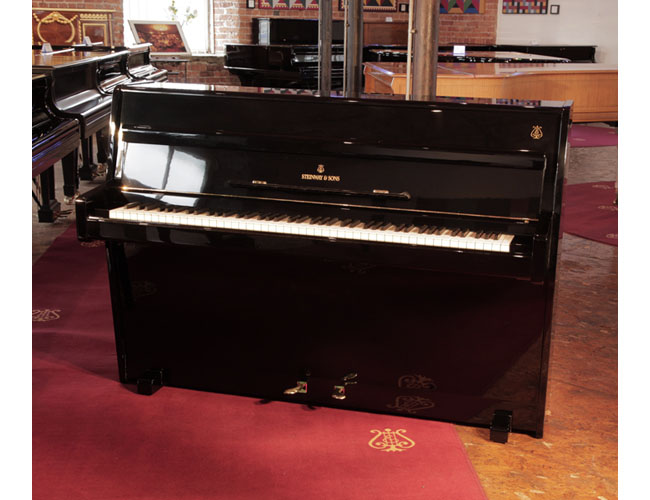 Reconditioned, 1960, Steinway Model F upright piano for sale with a black case and brass fittings.  Piano has an eighty-eight note keyboard and two pedals. 