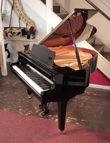 A 2009, Yamaha GB1 baby grand piano with a black case and square, tapered legs. Piano has an eighty-eight note keyboard and a three-pedal lyre.