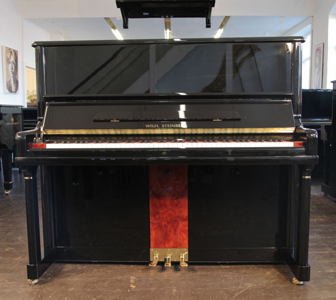 A Brand New Steinberg Model AT-32 upright piano with a black case, walnut panel and brass fittings. Piano features a carbon fibre action, eighty-eight note keyboard and three pedals