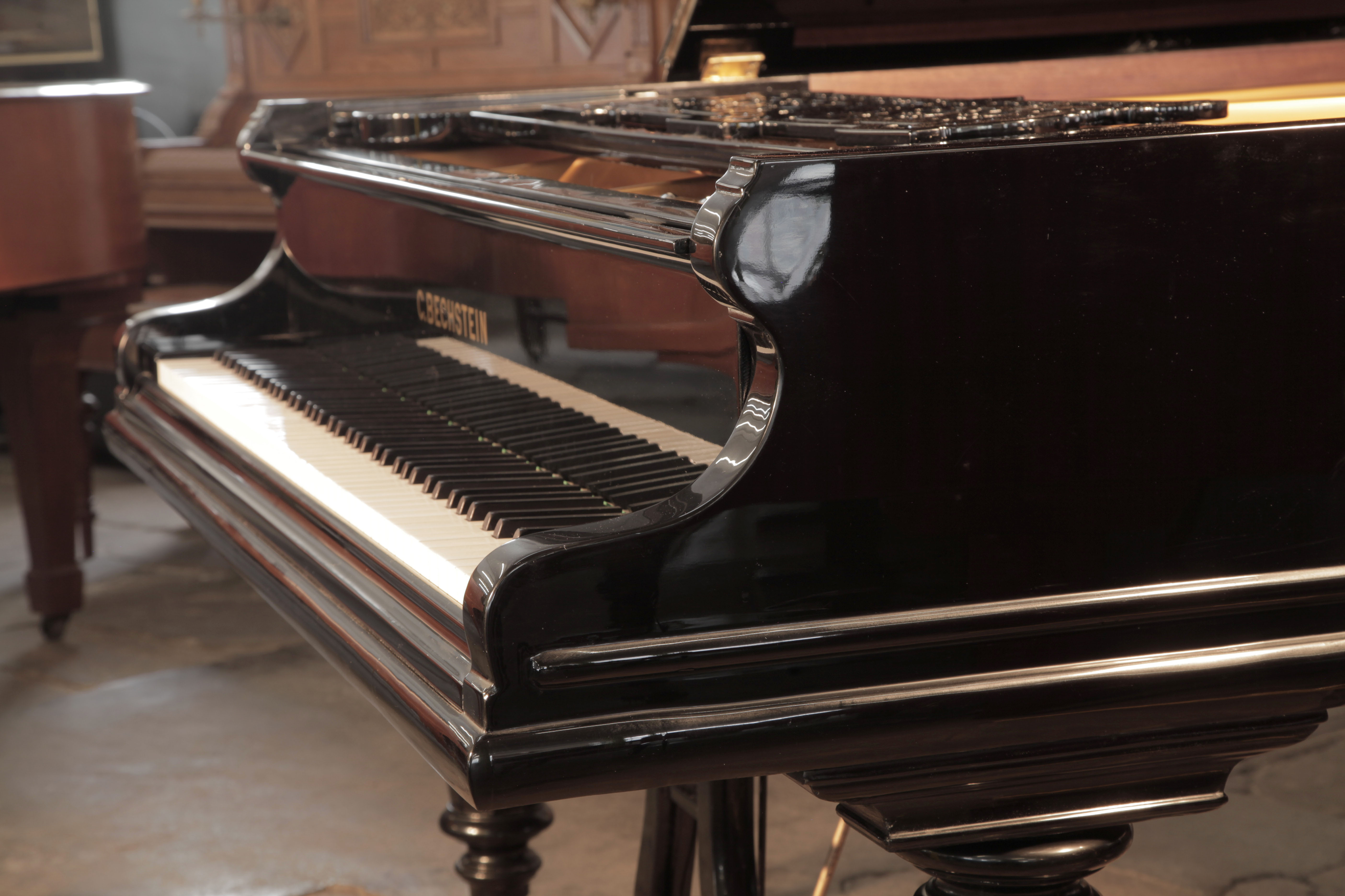 Bechstein Model V rounded piano cheek with linear case moulding that wraps around the cabinet base
