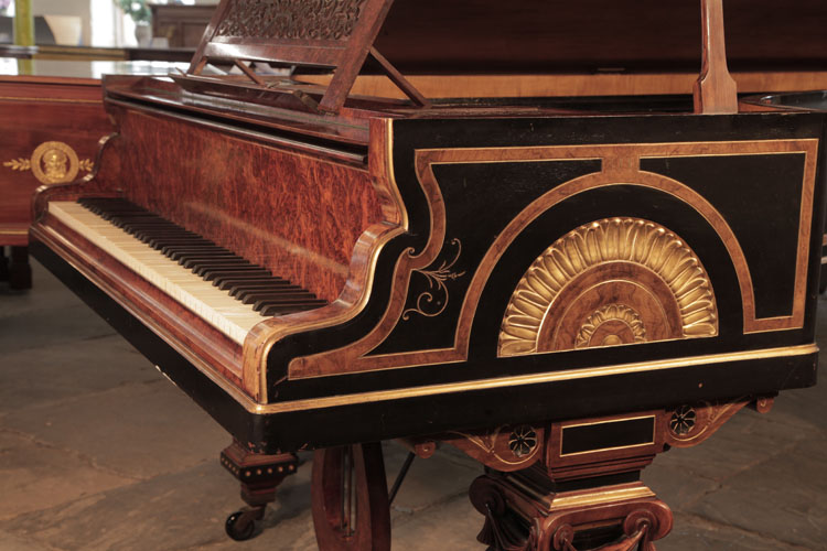 Erard serpentine piano cheek in black with burr walnut and gilt borders. Cheek features a carved motif of a sun disk surrounded by golden lotus leaves