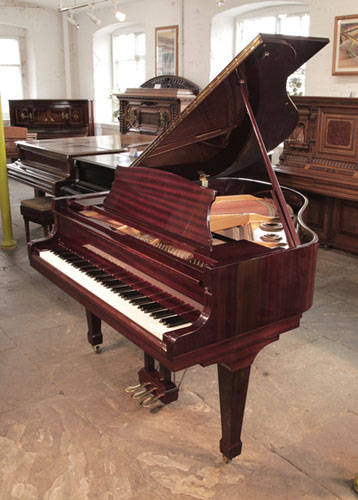  A 1986, Kawai KG-1D baby grand piano with a mahogany case and spade legs. Piano has an eighty-eight note keyboard and a three-pedal lyre