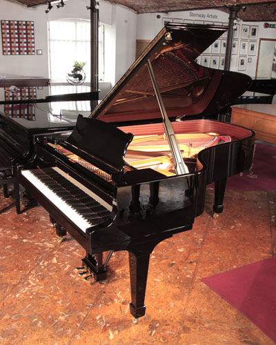 A 2008, Steinway Model B grand piano for sale with a black case and spade legs. Piano has a three-pedal lyre and an eighty-eight note keyboard.