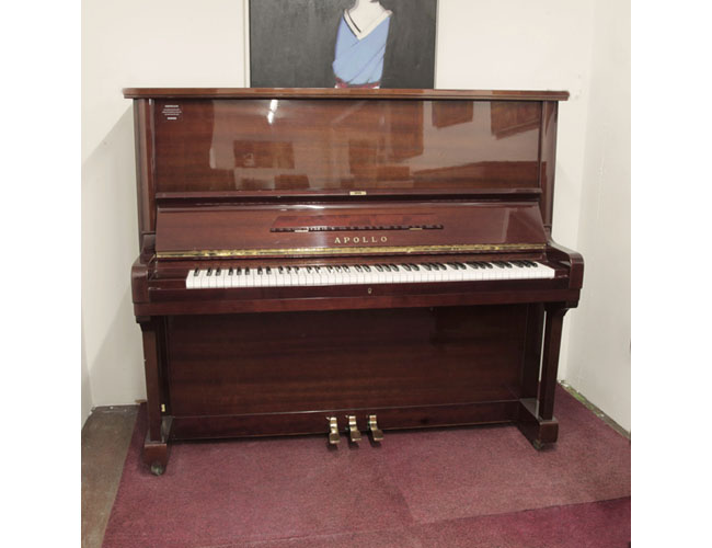 A 1980, Apollo A360 upright piano with a mahogany gloss case and Renner action. Piano has an eighty-eight note keyboard and three pedals. 