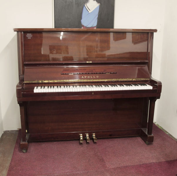 Pre-owned, Apollo A360 upright piano with a mahogany gloss case and Renner action. Piano has an eighty-eight note keyboard and three pedals.