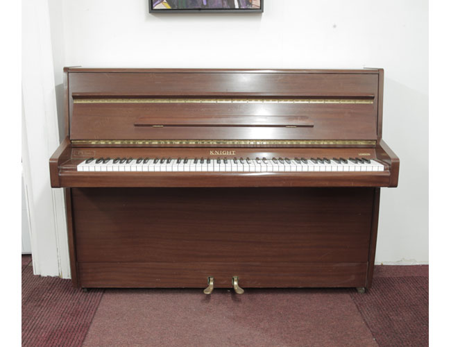 A 1970, Knight upright piano with a mahogany case. Piano has an eighty-eight note keyboard and two pedals 