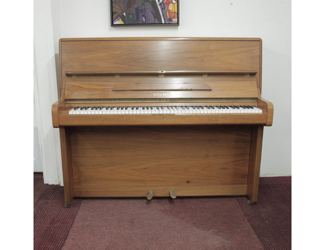A 1981, Welmar upright piano with a walnut case and Schwander action. Piano has an eighty-eight note keyboard and two pedals. 