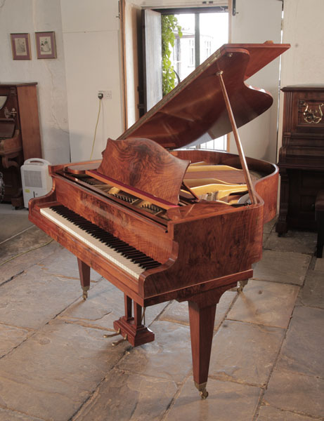 A 1936, Bechstein  baby grand piano for sale with a book-matched, figurative walnut case and square tapered legs.  Piano has an eighty-eight note keyboard and a two-pedal lyre. 