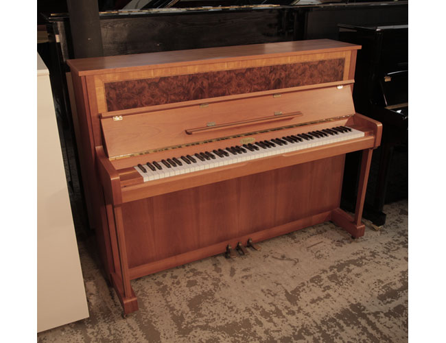 Reconditioned, 1992, Kemble upright piano with a crown-cut walnut case. Cabinet features a book-matched, burr walnut front panel.